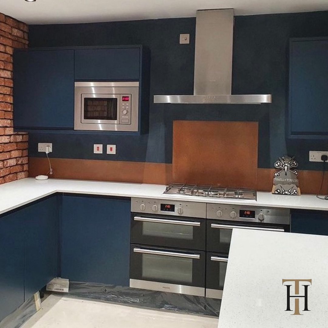 orange burnished splashback in blue modern kitchen